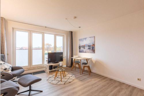 a living room with a tv and a table and chairs at Haus Knechtsand, Whg 447 in Duhnen