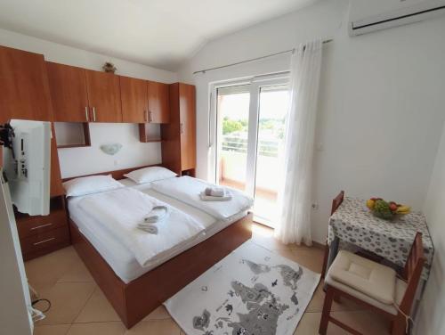 a bedroom with a bed and a table and a window at Apartments Marta in Seline