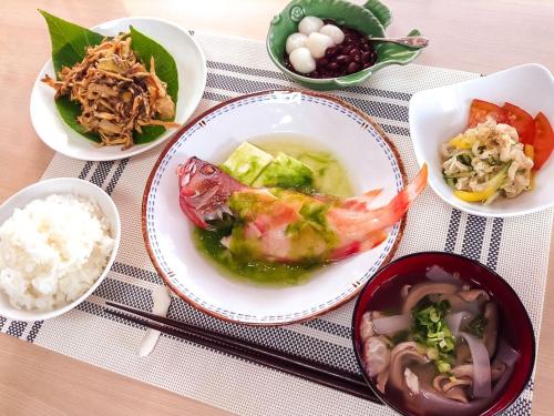 stół z miskami jedzenia i ryżu w obiekcie Minshuku Yadokari w mieście Zamami