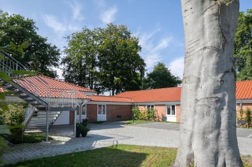 a brick house with a red roof at Weberhof Ferienapartments in Rostrup am Westufer des Zwischenahner Meers in Bad Zwischenahn