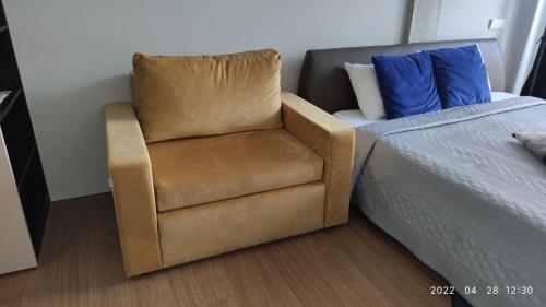 a chair next to a bed next to a bed at HaPPy Inn GOLD Studio, self check-in, Parking in the underground garage in Vilnius