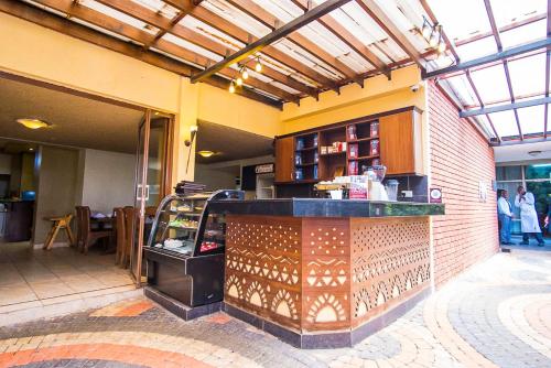 a restaurant with a counter in a building at Ngong Hills Hotel in Nairobi