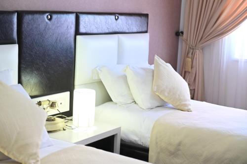a hotel room with two beds with white pillows at Hotel Liss in Lezhë