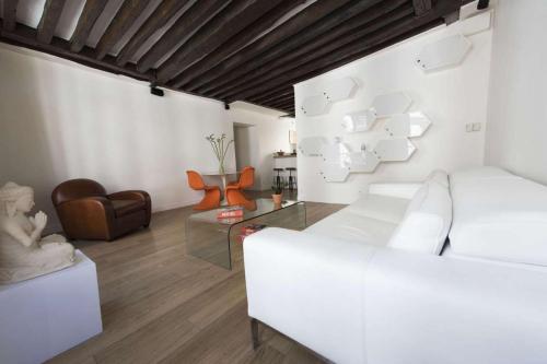 un salon avec un canapé blanc et une table en verre dans l'établissement Lucius, à Paris