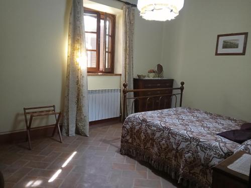 a bedroom with a bed and a window at Agriturismo Collesassi in Montalcino