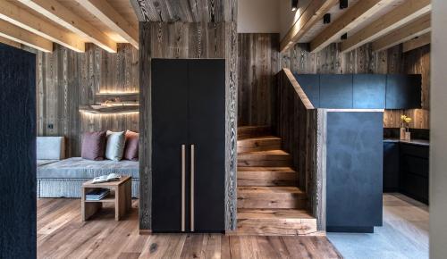 a kitchen and a living room with a refrigerator and a staircase at Kessler's Mountain Lodge in Natz-Schabs