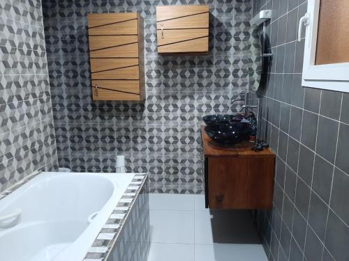 a bathroom with a bath tub and a sink at Résidence Fleur de la petite côte in Mbour