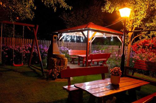 a picnic table and a gazebo in a garden at night at ORION in Karpacz