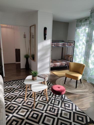 un salon avec une table et des chaises et un lit dans l'établissement Lodge Du Petit Lion proche DISNEYLAND PARIS, à Montévrain