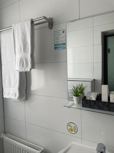 a white bathroom with a mirror and a sink at Hotel Post Sindelfingen in Sindelfingen