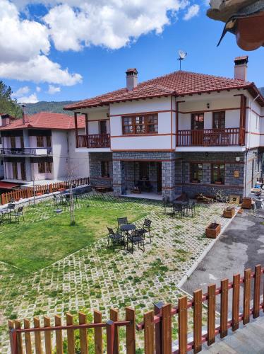 a large house with a yard with tables and chairs at NUCA GUESTHOUSE in Metsovo
