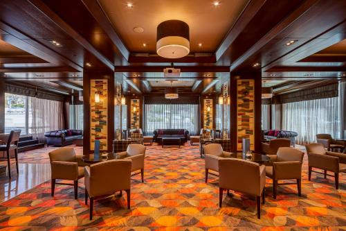 a lobby with tables and chairs in a building at Divan Ankara in Ankara