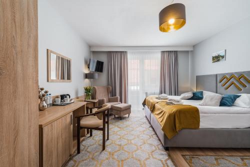 a hotel room with a bed and a desk at Hotel Smile Pieniny in Szczawnica
