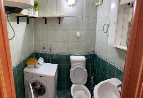 y baño pequeño con aseo y lavadora. en Apartman Barbara en Kotor