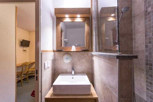 a bathroom with a sink and a mirror at Hôtel L'Echaillon in Névache