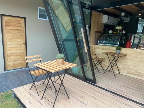 une table et des chaises en bois sur une terrasse dans l'établissement Hug Udon Hotel, à Udon Thani