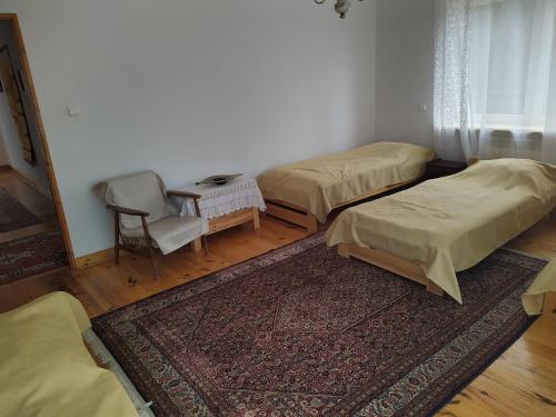 a room with three beds and a table and a chair at Gospodarstwo Agroturystyczne w Borszycach in Wola Pękoszewska
