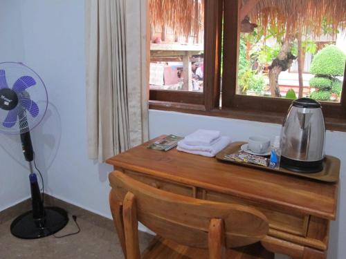 a desk with a fan next to a window at Gedong Khayangan in Tabanan