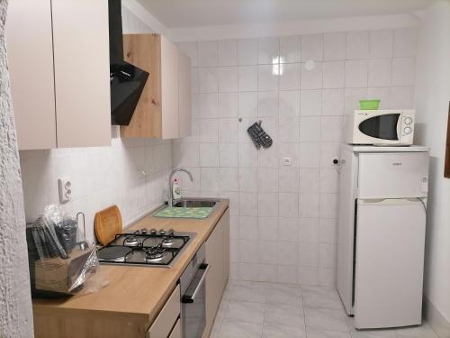 a small kitchen with a stove and a refrigerator at Apartman Zepina in Pula