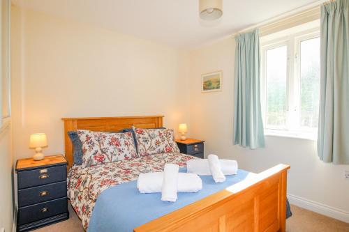 1 dormitorio con 1 cama con toallas en Corfe Lodge, en Corfe Castle