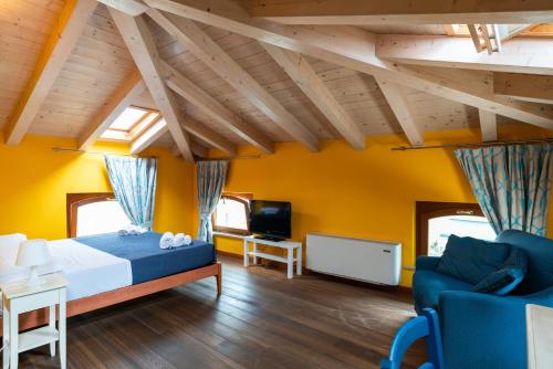 1 dormitorio con cama, sofá y TV en Gemma Rentals en Garda