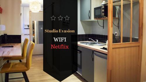 - une cuisine avec un réfrigérateur noir à côté d'une table dans l'établissement Studio Evasion, à Amiens