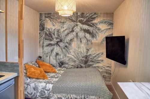 - une chambre dotée d'un lit avec des oreillers orange dans l'établissement Studio Evasion, à Amiens