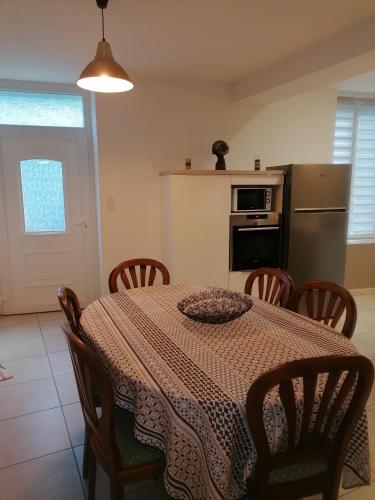 une salle à manger avec une table et des chaises et une cuisine dans l'établissement Chez Lydie, à Cessenon
