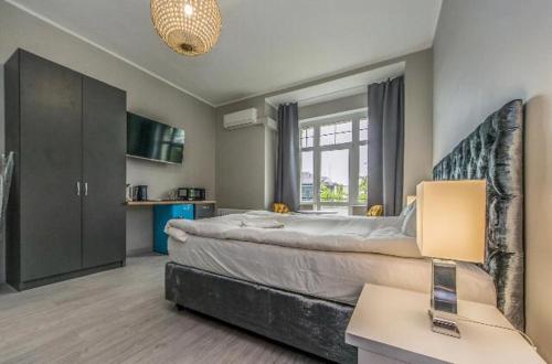 a bedroom with a large bed and a window at La Casa del Grand Apartments Sopot in Sopot
