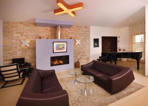 a living room with a couch and a piano at VELANERA Hotel & Restaurant in Medulin