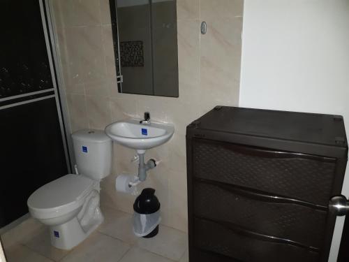 małą łazienkę z toaletą i umywalką w obiekcie Hospedaje casa Blanca, la mejor opción en Guaviare w San José Del Guaviare