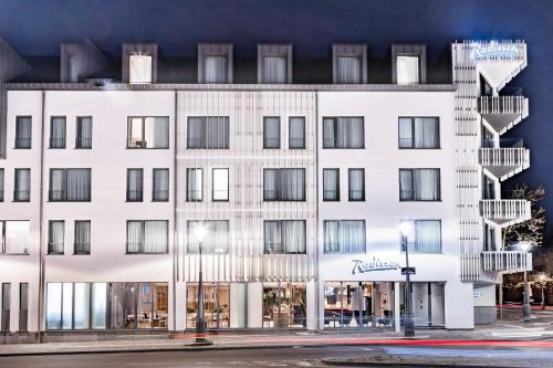 a white building on a city street at Radisson Hotel Liege City Centre in Liège