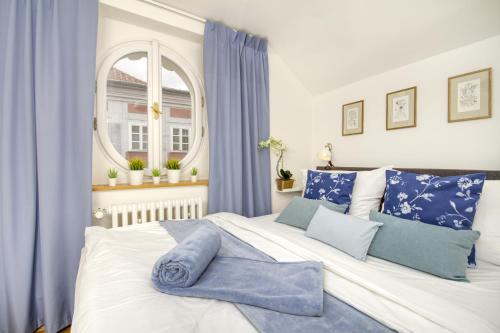 a bedroom with a large white bed with blue pillows at Charming APT Old Town Prague by Michal&Friends in Prague