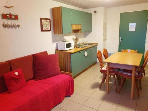 sala de estar con sofá rojo y cocina en Charmant Studio Duplex 26m2 à la montagne, en Praz-sur-Arly