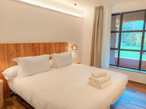 een slaapkamer met een wit bed en handdoeken bij HOTEL MAS ARET in Peralada