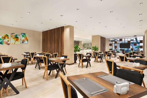 un ristorante con tavoli e sedie in legno e una tavola di Ramada By Wyndham Elbistan a Elbistan