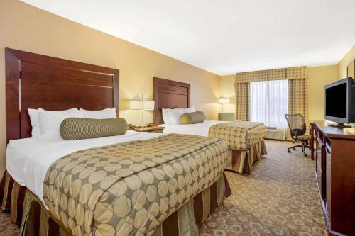 a hotel room with two beds and a television at La Quinta by Wyndham Dickinson in Dickinson