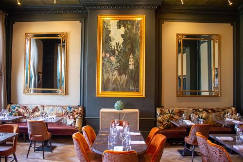 a dining room with tables and chairs and mirrors at White Hart Hotel & Apartments in Harrogate