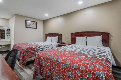 a hotel room with two beds and a desk at Econo Lodge Waco North I-35 in Waco