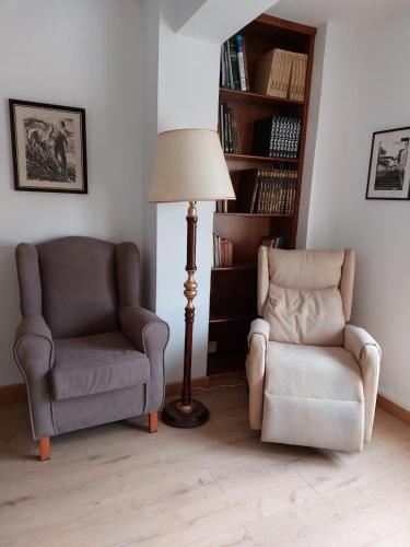 a living room with two chairs and a lamp at apartamento buenavista in Luarca
