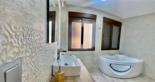 a bathroom with a large white tub and a sink at La casita del Agua in Úbeda