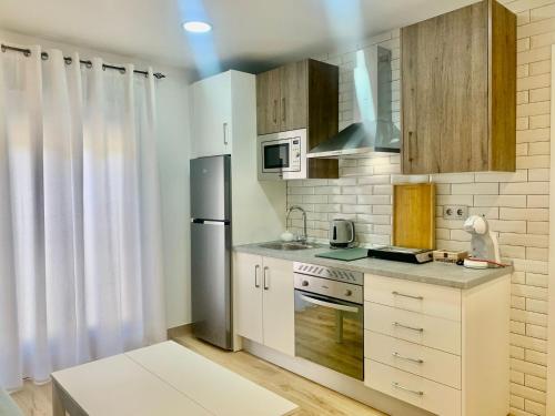 a kitchen with white cabinets and a stove top oven at La casita del Agua in Úbeda