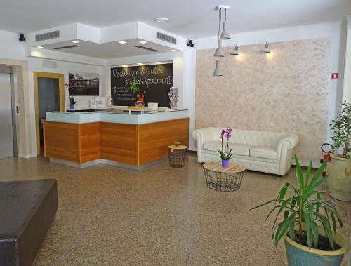 una hall con bancone e divano in camera di Residence & Suites a Bellaria-Igea Marina