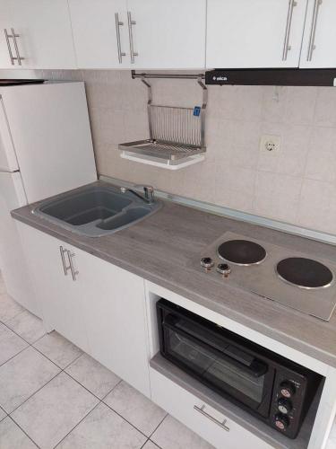 a kitchen with a sink and a stove at Kassandros Studios - Hanioti Halkidiki in Hanioti