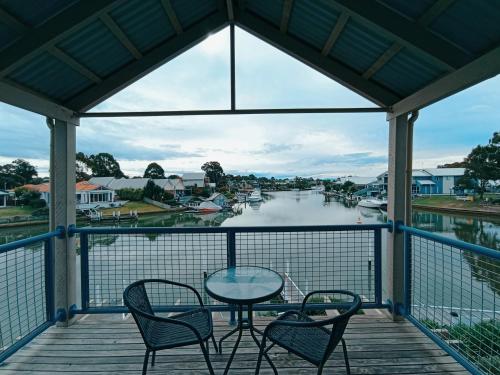 a table and chairs on a balcony with a view of a river at The View - Captains Cove Waterfront Resort in Paynesville