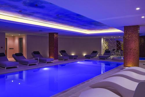 a swimming pool in a hotel with chairs and lights at Radisson Collection Morina Hotel, Tirana in Tirana