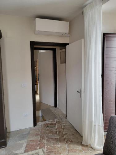 a hallway with a white door and a white curtain at Ancient Stone 'Casa Rosa'- Sea and Mountain View Tranquil Borgo in Tavenna