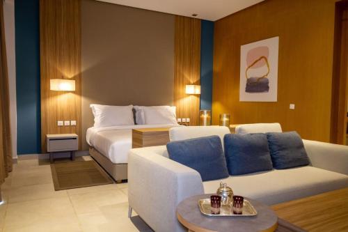 une chambre d'hôtel avec un canapé et un lit dans l'établissement Zephyr Mazagan, à El Jadida
