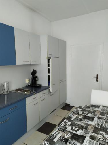 a kitchen with white cabinets and a blue counter top at Monteurzimmer EZ GROß in Frankfurt/Oder