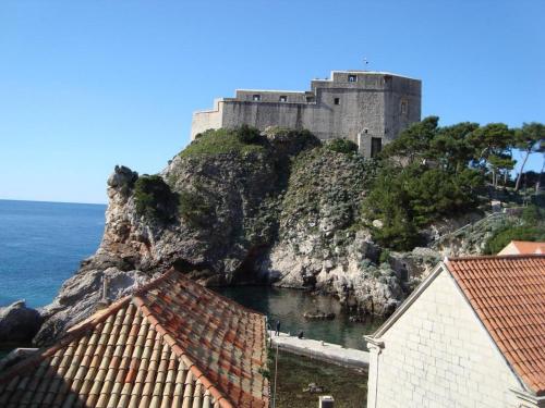 un castillo en la cima de una montaña junto al océano en Rooms Lovrijenac, en Dubrovnik